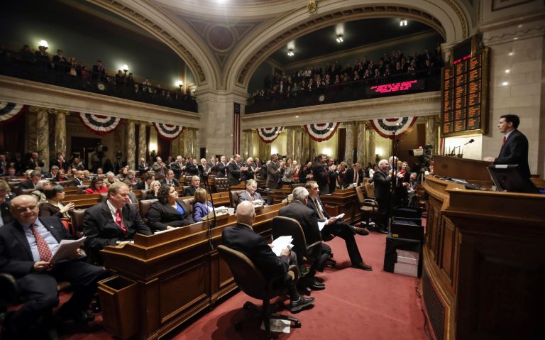 This photo taken Jan. 23, 2014 shows Wisconsin Gov. Scott Walker, right, addressing legislators during the Governor's State of the State speech in the Assembly chambers at the state Capitol in Madison, Wis. Walker introduced new members of his state's workforce and said the proceeds from a projected budget surplus belong to the taxpayers. All governors look forward to an annual address before state lawmakers and the public, a mini-bully pulpit that offers a televised platform to publicize their accomplishments and rally support for their agenda. For a group of governors with White House aspirations, the speeches offer a framework for how they might appeal to early voting states like Iowa, New Hampshire and South Carolina, and how they might one day govern. (AP Photo/Andy Manis)