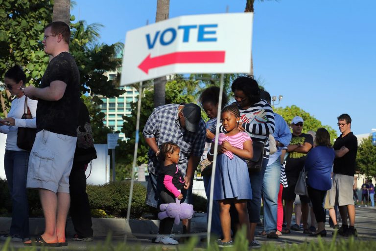 Early voters wait in line to vote in the presidential election on the first day of early voting at a polling station setup at the City of Miami City Hall on October 27, 2012 in Miami, Florida. (Photo by Joe Raedle/Getty images)