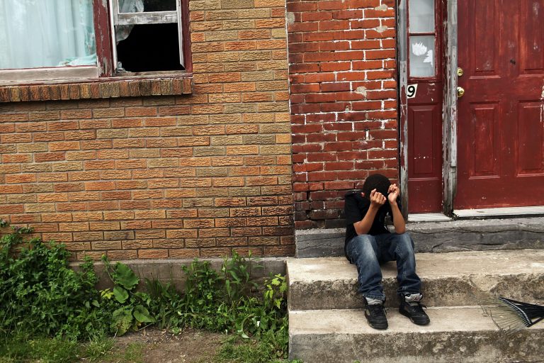 A child sits on a stoop in a working class section of Utica on May 14, 2012 in Utica, New York. Like many upstate New York communities, Utica is struggling to make the transition from a former manufacturing hub.
