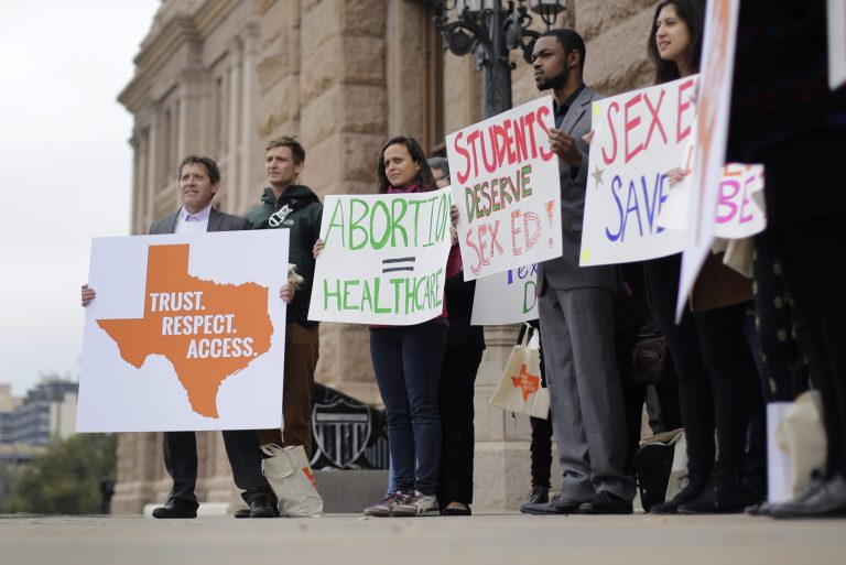 Students and abortion rights activists hold signs during a rally on the steps of the Texas Capitol.Â A federal appeals court has upheld a Texas law requiring abortion clinics to have hospital-grade facilities.Â (AP Photo/Eric Gay)