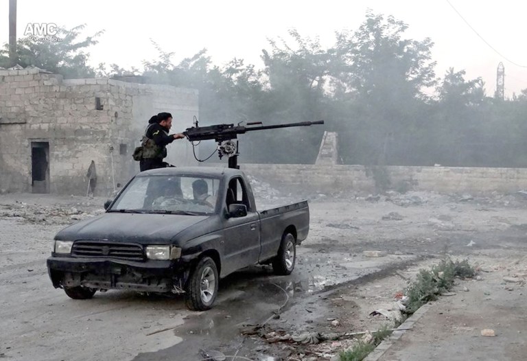 Aleppo Media Center/AP
A Syrian rebel fires a heavy machine gun towards Syrian soldiers loyal to Syrian President Bashar Assad in Aleppo.