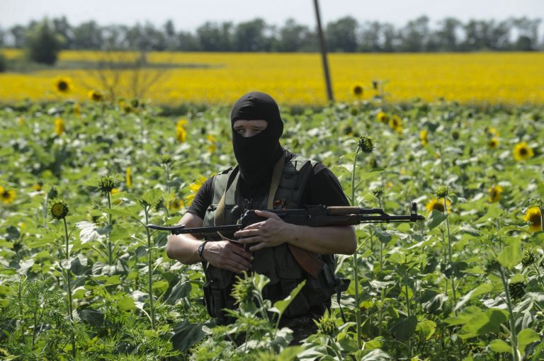 A pro-Russian fighter guards the crash site of Malaysia Airlines Flight 17 near the village of Hrabove, eastern Ukraine, Sunday, July 20, 2014. Rebels in eastern Ukraine took control Sunday of the bodies recovered from downed Malaysia Airlines Flight 17, and the U.S. and European leaders demanded that Russian President Vladimir Putin make sure rebels give international investigators full access to the crash site.(AP Photo/Evgeniy Maloletka)