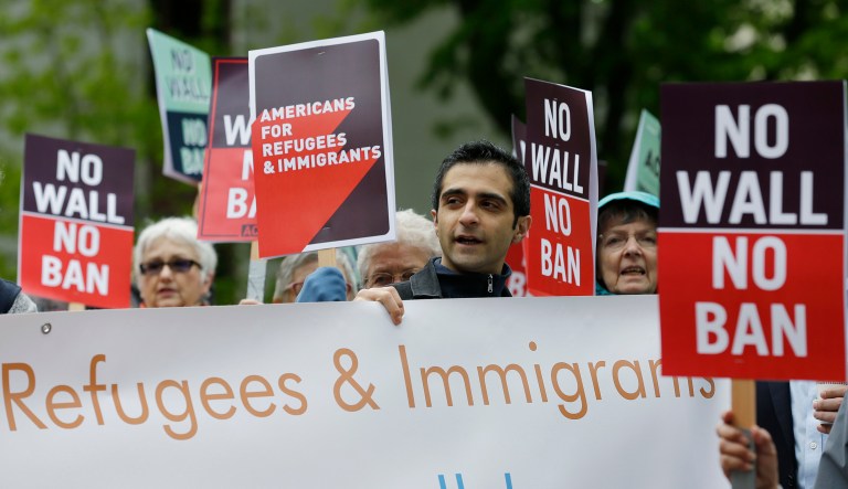 Protesters hold signs during a demonstration against President Trump's revised travel ban outside a federal courthouse. (AP Photo/Ted S. Warren)