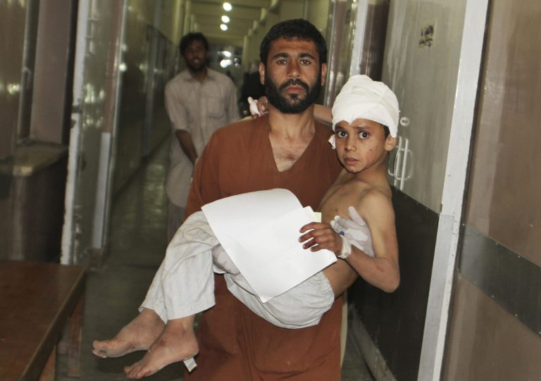 A young injured Afghan boy is carried by his father into the emergency room at the hospital in Kandahar, Afghanistan, Friday, May 17, 2013 after a car bomb exploded inside an elite gated community linked to the family of Afghan President Hamid Karzai. Many people where killed and scores wounded, an official said.(AP Photo/Allauddin Khan)