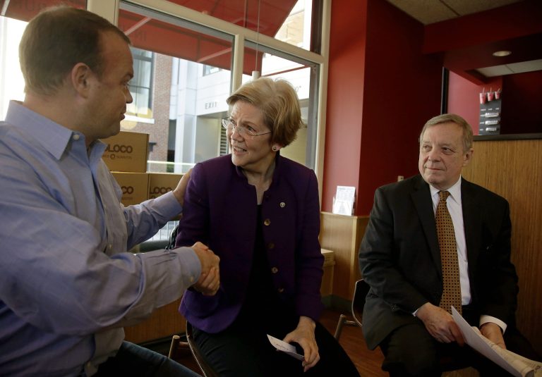 Sen. Elizabeth Warren, D-Mass., shakes hands with Boloco founder John Pepper as Senate Majority Whip Richard Durbin of Illinois looks on during a minimum wage roundtable discussion held at Boloco, a fast food chain of burrito restaurants in Boston, on Feb. 10. Beloco pays a minimum wage of $9.00 per hour, and the current federal minimum is $7.25 per hour. (AP Photo/Stephan Savoia)