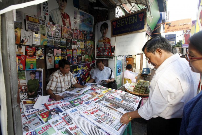   Customers buy weekly news journal at a roadside newspaper shop in Yangon, Myanmar, Friday, Dec. 28, 2012. Myanmar said Friday it will allow private daily newspapers starting in April for the first time since 1964, in the latest step toward allowing freedom of expression in the long-repressed nation. (AP Photo/Khin Maung Win)  