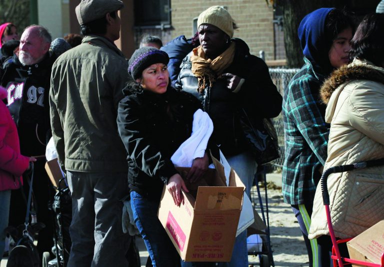 A woman holds a box of food she picked up at an American Red Cross station in the Coney Island section of Brooklyn, Monday, Nov. 5, 2012 in New York. The region is still cleaning up a week after Superstorm Sandy. (AP Photo/Mark Lennihan)