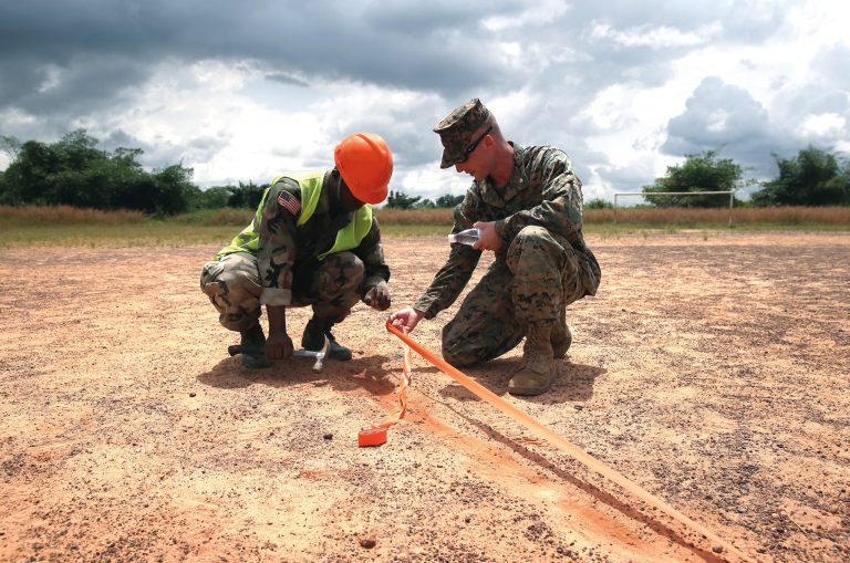 A  Liberian soldier and a U.S. Marine set up a landing zone next to an Ebola treatment center on October 11, 2014 in Tubmanburg, Liberia. (John Moore/Getty Images)