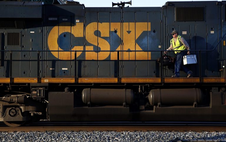 In this March 22, 2014 picture, a crew member walks on a CSX freight train engine in Brunswick, Md. CSX Corp. reports quarterly earnings after the market close on Tuesday, April 15, 2014. (AP Photo/Patrick Semansky)