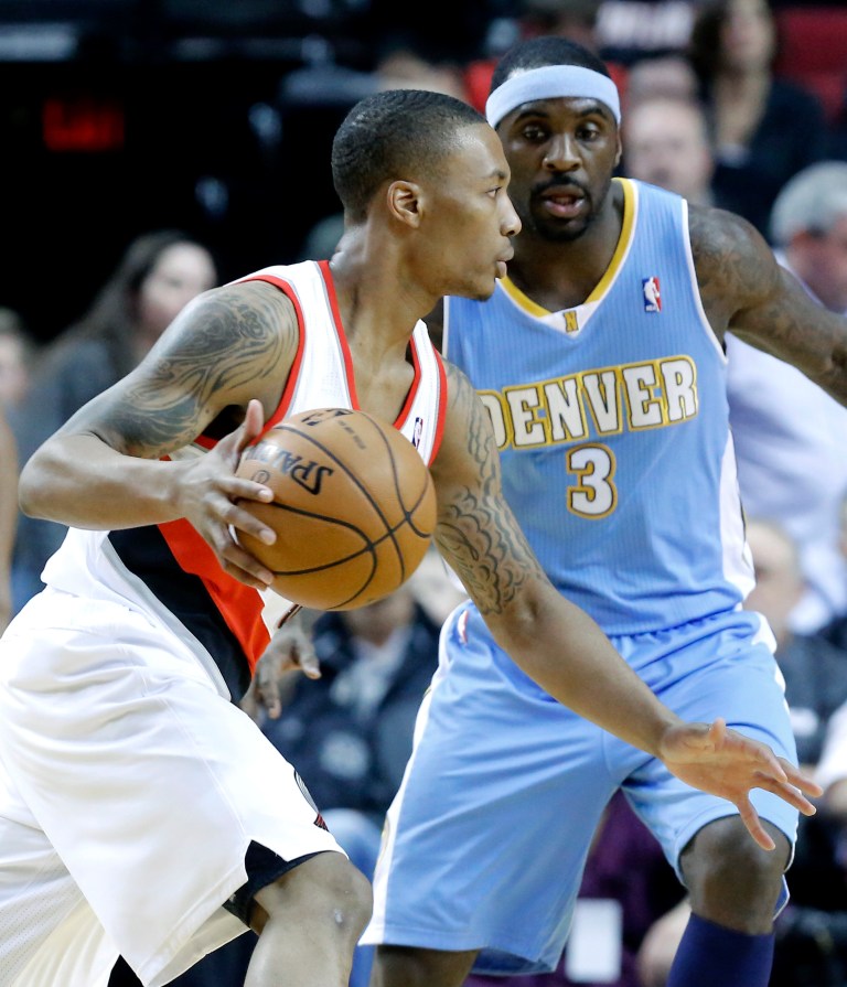   Portland Trail Blazers guard Damian Lillard, left, drives against Denver Nuggets guard Ty Lawson during the first quarter of an NBA basketball game in Portland, Ore., Thursday, Dec. 20, 2012. (AP Photo/Don Ryan)  