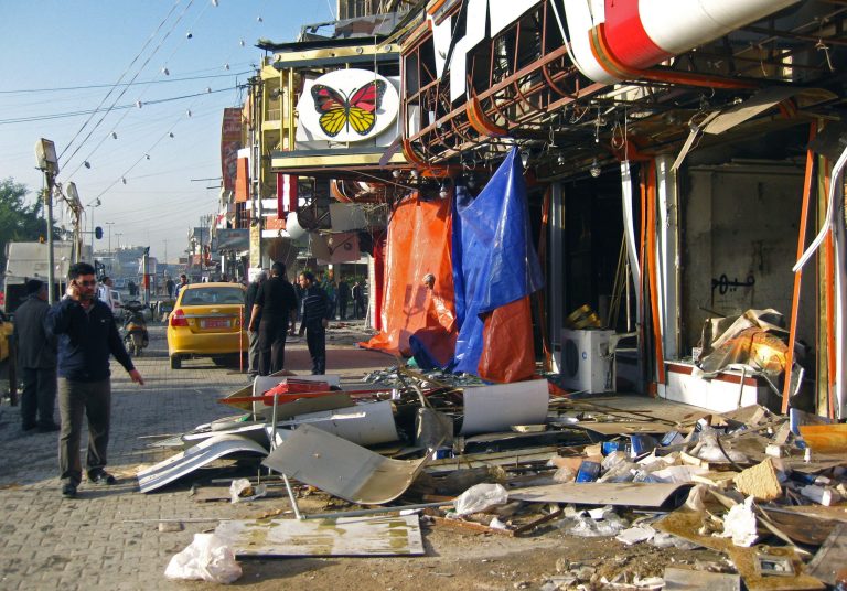 Civilians inspect the aftermath of a car bomb attack near the al-Farasha pastry shop in the southeastern district of New Baghdad, Iraq, Thursday, Jan. 30, 2014. Car bombs and a shooting, mainly in Shiite areas, killed and wounded scores of people in the Iraqi capital on Wednesday, officials said, as authorities released a rare photograph of a man they say is the leader of al-Qaida's local branch. Since late December, members of Iraq's al-Qaida branch have taken over parts of Ramadi, capital of the largely Sunni province of Anbar. They also control the center of the nearby city of Fallujah. Government forces and allied tribes have been trying to wrest control back from the militants. (AP Photo/Khalid Mohammed)