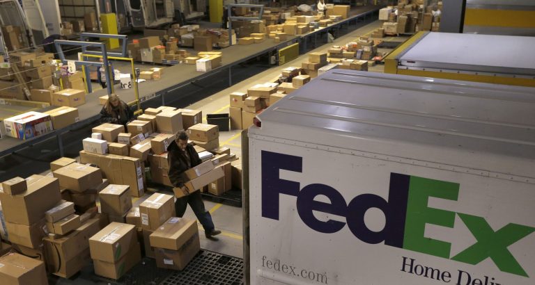   FILE - In this Monday, Dec. 10, 2012, file photo, workers sort packages at a FedEx sorting facility in Kansas City, Mo. FedEx is more pessimistic about the U.S. economy than it was three months ago, but more assured of its own ability to grow earnings. The world's second-largest package delivery company lowered its economic forecast for the U.S., saying that there remains a lot of uncertainty for the company and the country. Its forecast for the current quarter, which incorporates the critical holiday season, falls short of Wall Street expectations. (AP Photo/Charlie Riedel, File)  