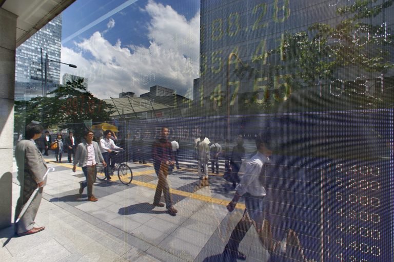 Pedestrians are reflected on the electronic stock indicator of a securities firm in Tokyo Thursday, May 22, 2014. Japan's Nikkei led gains in Asian stock markets Thursday after a manufacturing survey suggested the slowdown in China's economy is flattening out and Fed minutes reinforced expectations the U.S. central bank won't rush to raise interest rates. Japan's Nikkei 225 rose 295.62 points, or 2.1 percent to 14,337.79. (AP Photo/Shizuo Kambayashi)