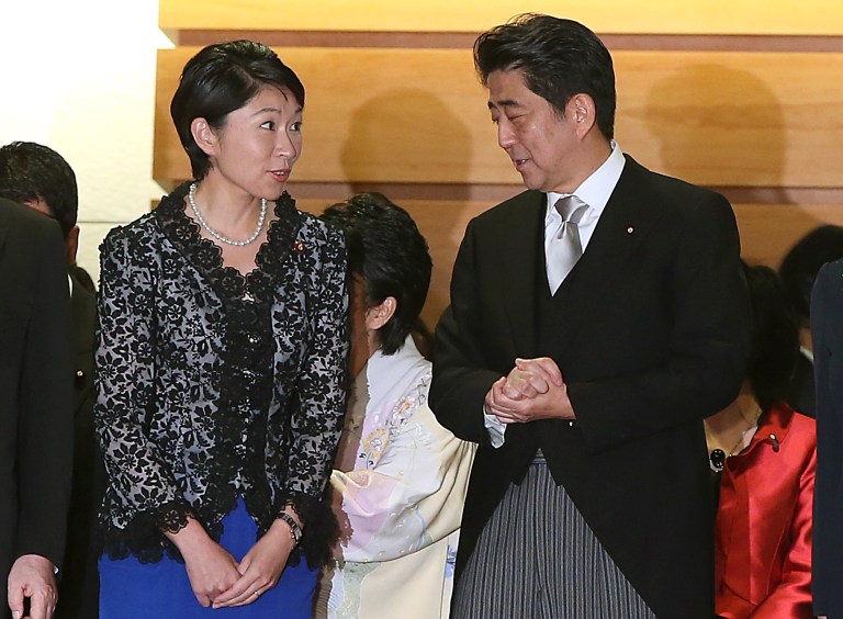 FILE - In this Sept. 3, 2014 file photo, Japan's Prime Minister Shinzo Abe, right, and his newly appointed Trade Minister Yuko Obuchi chat prior to a group photo session following the first Cabinet meeting at the prime minister's official residence in Tokyo. Obuchi was peppered with questions in parliament Thursday, Oct. 16 over her political spending in the latest scandal involving female members in Abe's Cabinet. Three other female ministers have been questioned over campaign giveaways, gaffes or alleged links to racist groups. (AP Photo/Eugene Hoshiko, File)