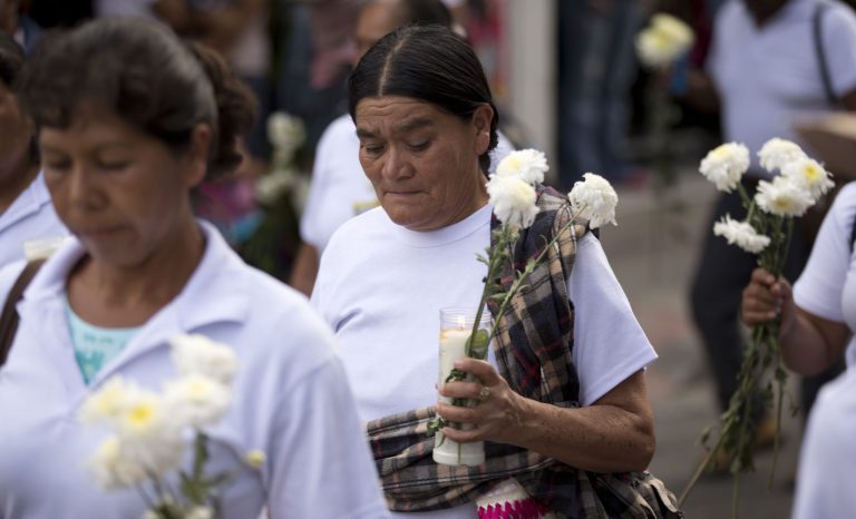 Relatives of missing students march with flowers and candles to protest the disappearance of 43 students from the Isidro Burgos rural teachers college in Chilpancingo, Mexico, Tuesday, Oct. 14, 2014. According to Mexico's attorney general none of the missing students were among the bodies found in the first set of mass graves outside the town. Authorities have said police involved in 