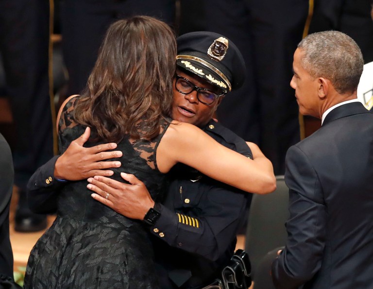 First lady Michelle Obama, left, hugs Dallas Police Chief David Brown, as President Barack Obama, right, watches during a memorial service at the Morton H. Meyerson Symphony Center with the families of the fallen police officers in Dallas. (AP Photo/Eric Gay)
