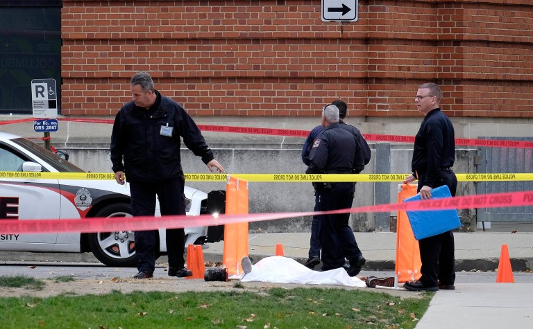 Police cover the body of a suspect outside Watts Hall on the campus of Ohio State University in Columbus, Ohio, following an attack on campus that left several people injured on Monday. (Adam Cairns/The Columbus Dispatch via AP)