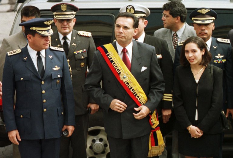 FILE - In this Jan. 15, 2000 file photo, Ecuador's President Jamil Mahuad, center, his daughter Paola Mahuad, right, and military officials arrive to Congress in Quito, Ecuador. Ecuadorean authorities announced on Tuesday, May 27, 2014 via Twitter that an arrest warrant has been issued for former President Jamil Mahuad for allegedly misappropriating public funds during the country's late 1990s banking crisis. Mahuad fled a 2000 coup and settled in the United States. (AP Photo/Silvia Izquierdo, File)