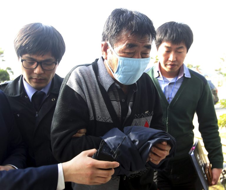 Lee Joon-seok, center, the captain of the sunken ferry Sewol in the water off the southern coast, arrives at the headquarters of a joint investigation team of prosecutors and police in Mokpo, south of Seoul, South Korea, Saturday, April 19, 2014.  The captain of the sunken ferry, leaving more than 300 missing or dead, was arrested early Saturday on suspicion of negligence and abandoning people in need. Two crew members also were taken into custody, including a mate who a prosecutor said was steering in challenging waters unfamiliar to her when the accident occurred. (AP Photo/Yonhap) KOREA OUT