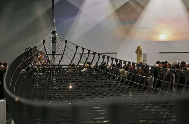 Visitors wander around a new exhibition entitled 'Vikings: Life and Legend' at the British Museum in central London, Tuesday, March 4, 2014. The centerpiece of the show is the biggest Viking ship ever found, which was unearthed on the banks of a Danish fjord in 1997, it is 37 meters (120 feet) long and had 40 pairs of oars. Its scale is awe-inspiring, though imagination is required to picture it as it once was, because only about 20 percent of the ship's timbers remain, set within a modern steel skeleton the size and shape of the original vessel.  The new exhibition strives to make people think again about the Scandinavian pillagers who raided and struck terror into English villages.  The exhibition aims to show how Viking energy and ideas re-drew the map of the world, through the presentation of their ships, their weapons, their crafts, their words and even their skeletons. (AP Photo/Lefteris Pitarakis)