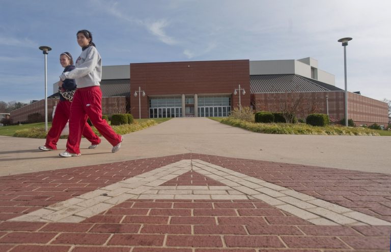 In this Nov. 12, 2009 photo, two students walk past Bud Walton Arena on the University of Arkansas campus on Thursday, Nov. 12, 2009, in Fayetteville, Ark. Legislators on Tuesday criticized how the university managed the budget of its fundraising division and said they're still not clear how it built a $4.2 million deficit. (AP Photo/Beth Hall)