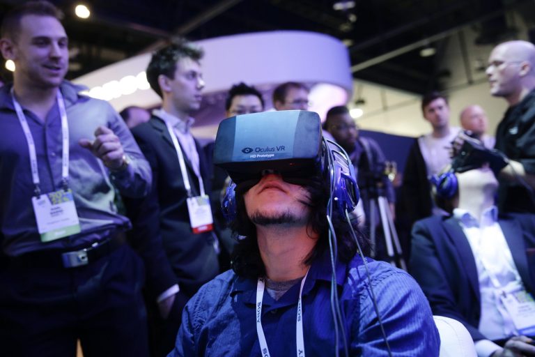 FILE - In this Jan. 7, 2014 file photo, show attendees play a video game wearing  Oculus Rift virtual reality headsets at the Intel booth at the International Consumer Electronics Show(CES), in Las Vegas. Facebook said Tuesday, March 25, 2014,  it has agreed to buy Oculus for $2 billion, betting that its virtual reality may be a new way for people to communicate, learn or be entertained. (AP Photo/Jae C. Hong, File)