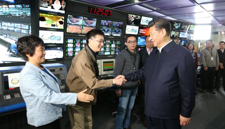 In this photo released by China's Xinhua News Agency, Chinese President Xi Jinping, right, shakes hands with staff members at the control room of China Central Television in Beijing. A November report by the U.S. China Economic and Security Review Commission found that Xinhua "serves some functions of an intelligence agency by gathering information and producing classified reports for the Chinese leadership."