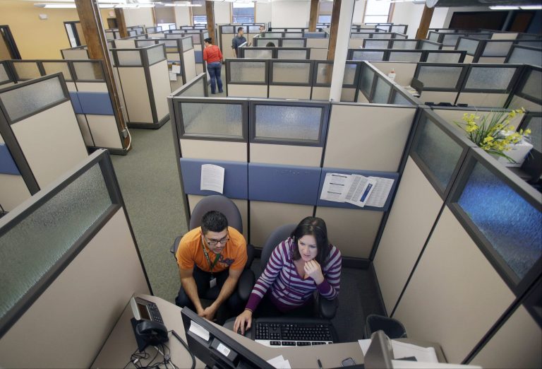 MNsure insurance exchange representatives Carlos Villanueva, left, and Emily Joyce prepare for the Oct. 1 open enrollment debut at the center in St. Paul, Minn., on Sept. 27. (AP File Photo)