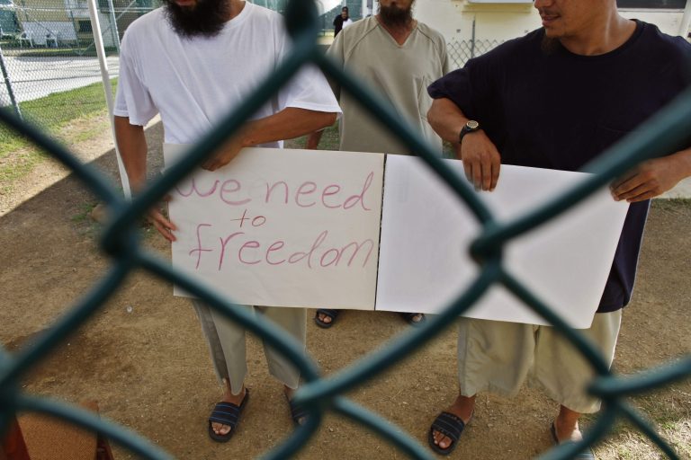 ChineseÃÂ UighurÃÂ Guantanamo detainees, who at the time were cleared for release but had no country to go to, show a home-made note to visiting members of the media at Camp Iguana detention facility at Guantanamo Bay U.S. Naval Base, Cuba. (AP/Brennan Linsley)