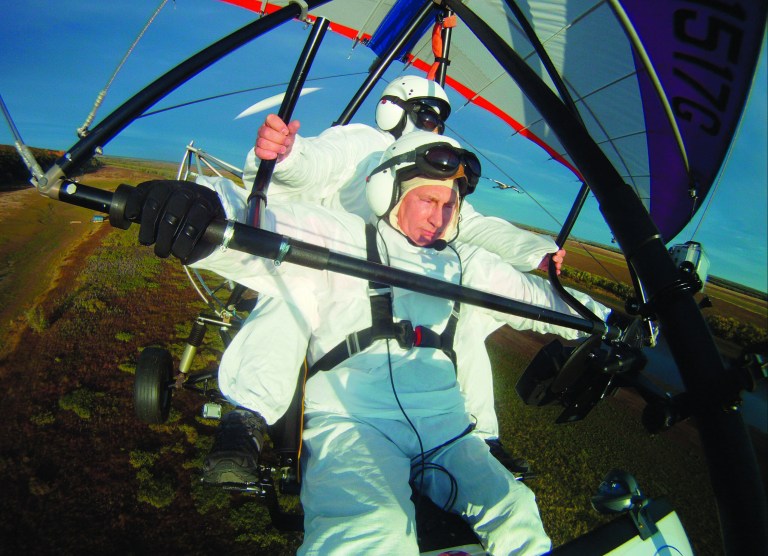 FILE - In this Wednesday Sept. 5, 2012 file photo, Russian President Vladimir Putin, (foreground) flies in a motorized hang glider alongside a Siberian white crane, on the Yamal Peninsula, in Russia. On Thursday, Nov. 1, 2012, Interfax reported that Putin's spokesman Dmitry Peskov said the president had pulled a muscle. 