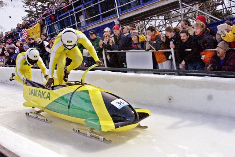 In this file photo, Winston Watts and Lascelles Brown of Jamaica push off during the men's two-man bobsled at the Salt Lake City Winter Olympics in Park City, Utah, on Feb. 16, 2002. Watts, a member of this year's Jamaican bobsled team as well, is seeking financial help to send his team to the Winter Olympics in Sochi, Russia, this year, and found it in the Dogecoin community. (AP Photo/Joe Cavaretta)
