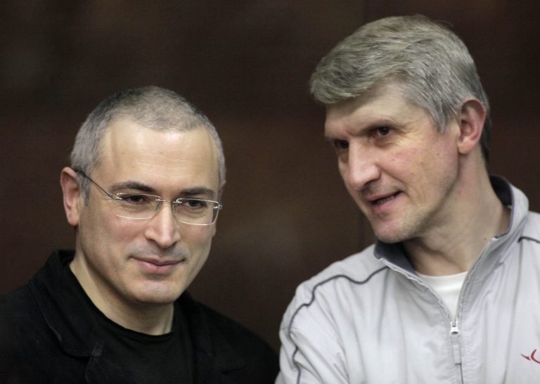 FILE - In this Dec. 30, 2010 file photo, former oil tycoon Mikhail Khodorkovsky, left, and his co-defendant Platon Lebedev talk behind a glass enclosure at a courtroom in Moscow. Russia's highest court ruled Thursday, Jan. 23, 2014 to free jailed business partner Lebedev of Khodorkovsky about three months early, but left in place a back tax claim of 17 billion rubles ($500 million) against Khodorkovsky that will in effect prevent him from returning to Russia. (AP Photo/Alexander Zemlianichenko Jr, File)