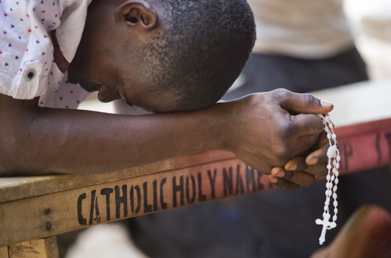 A Nigerian man prays in the yard of the St. Charles Catholic Church, scene of a 2014 bomb attack blamed on Boko Haram Islamic insurgents, in the mainly Christian Sabon Gari neighborhood of Kano, northern Nigeria on Palm Sunday, March 29, 2015. (AP Photo/Ben Curtis)