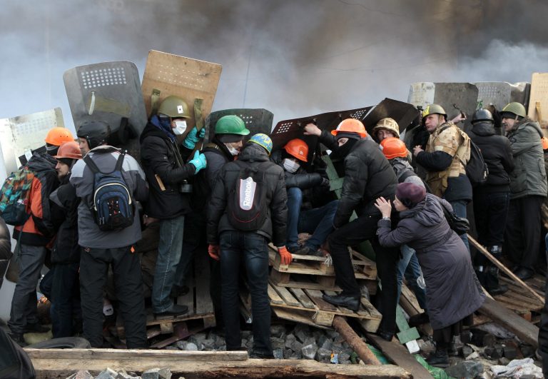 Anti-government protesters protected themselves with shields during clashes with riot police in Kiev's Independence Square, the epicenter of the country's current unrest, Kiev, Ukraine, on Wednesday. (AP/Sergei Chuzavkov)
