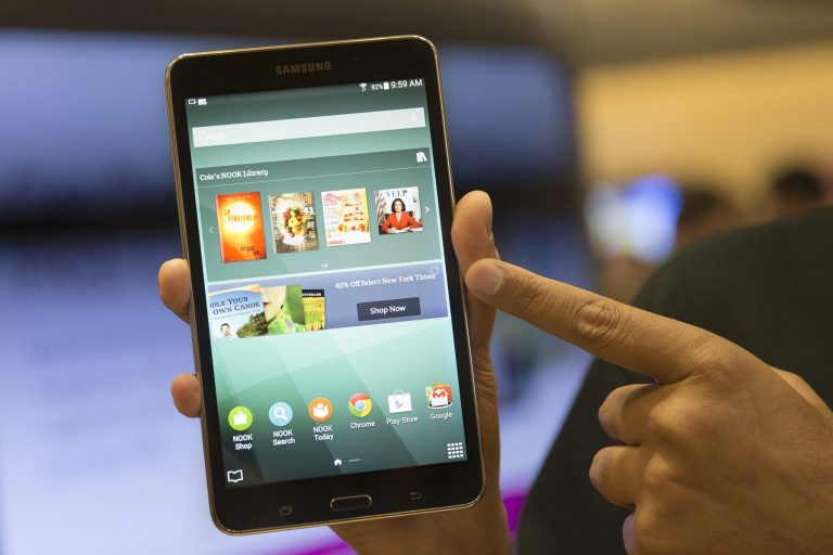 A brand ambassador handles a new Samsung Galaxy Tab 4 Nook during the unveiling of the co-branded tablet that will replace B&N's Nook, Wednesday, Aug. 20, 2014, in New York. The 7-inch tablet will sell for $179 after a $20 instant rebate, the same entry price of the non-branded Samsung Galaxy Tab 4. (AP Photo/John Minchillo)
