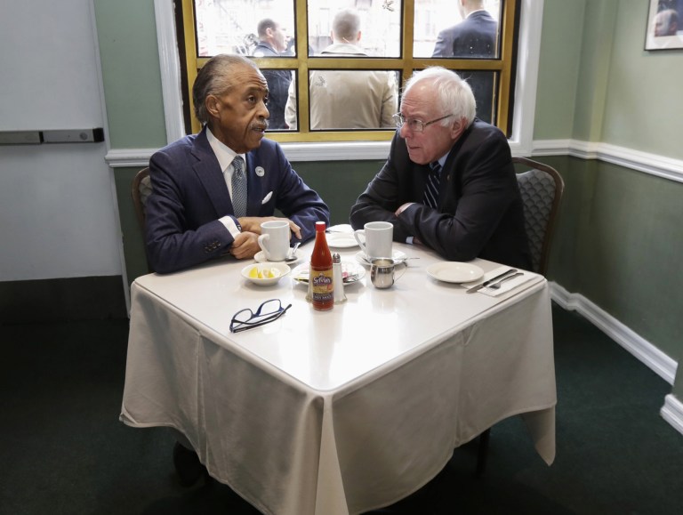 Rev. Al Sharpton talks with Democratic presidential candidate Sen. Bernie Sanders, I-Vt. as they sit down for a breakfast meeting at Sylvia's Restaurant. (AP Photo/Richard Drew)