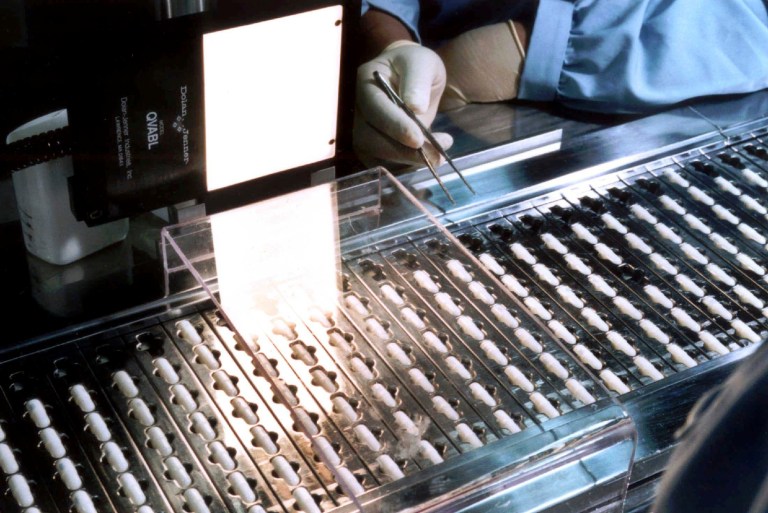 Capsules of Norvir, an AIDS drug, roll off the manufacturing line at Abbot Laboratories in Chicago, Ill., in February 1996. (AP File)