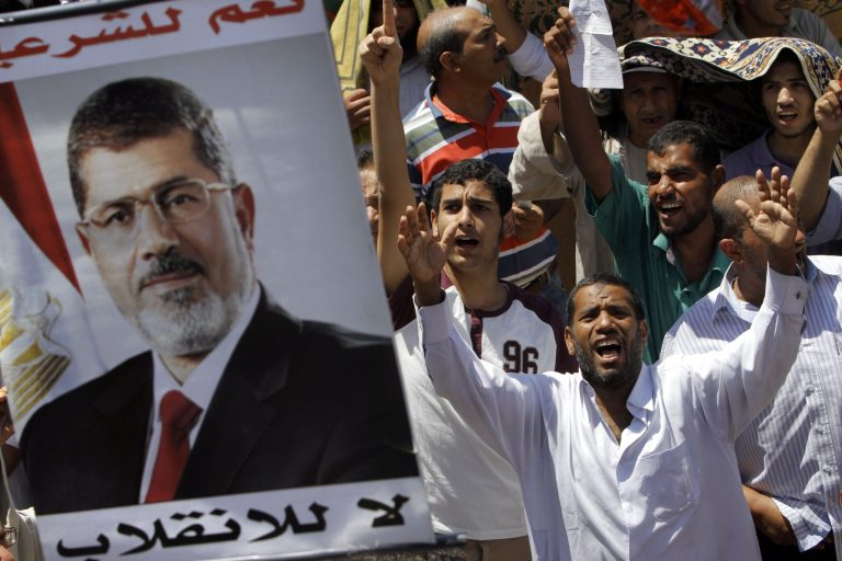 Supporters of Egypt's ousted President Mohammed Morsi shout slogans under his poster following Friday prayers in Nahda square, where protesters installed their camp near Cairo University in Giza, Egypt. (AP/Amr Nabil)