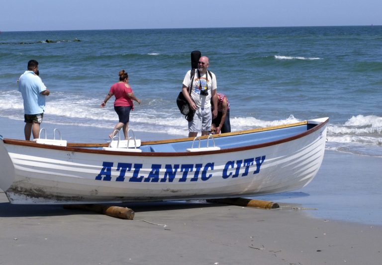 This June 16, 2014, photo shows people walking along the water's edge in Atlantic City, N.J. As three casinos prepare to shut down over the labor Day weekend, city and tourism officials are stressing the many non-gambling attractions that Atlantic City still offers. (AP Photo/Wayne Parry)