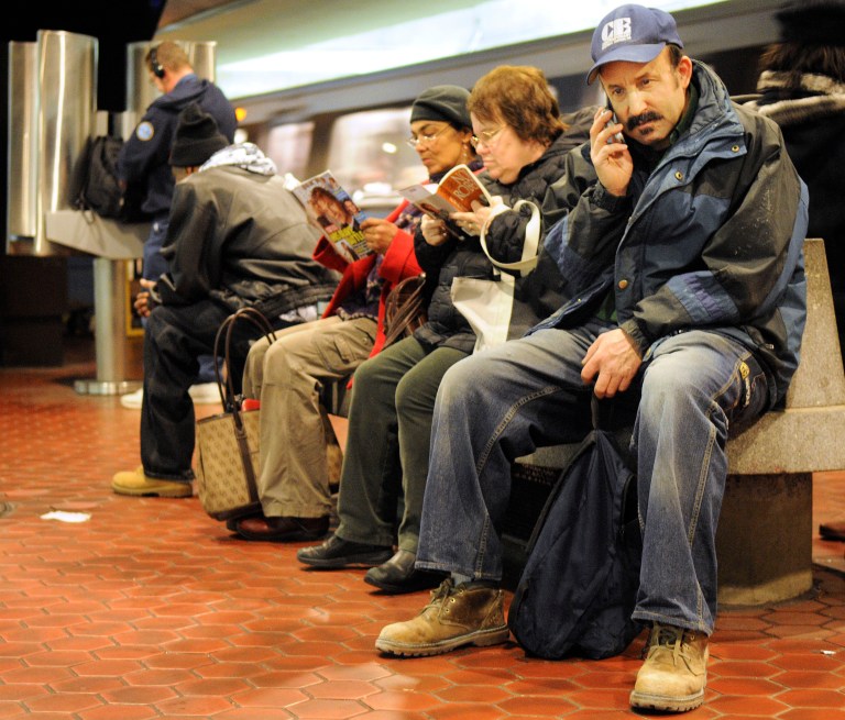 A man uses his cell phone at the Gallery Place-Chinatown station. (Examiner file photo)