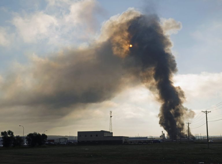 Smoke rises from the site of a fire in an industrial area of Williston, N.D. on Tuesday, July 22, 2014. Authorities have set up an evacuation zone within a half-mile radius of Red River Supply, the site of the fire. No injuries were immediately reported. Red River Supply provides services to oil companies working in North Dakota's oil patch. (AP Photo/Josh Wood)