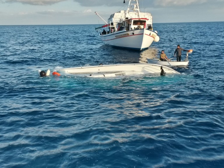 In this photo released by the Hellenic Coast Guard, local fishermen look a yacht used to transport immigrants illegally that overturned in a fatal accident near the Greek island of Samos, on Monday, May 5, 2014.  At least 22 people drowned in the incident in the eastern Aegean Sea, while 36 were rescued and others remain missing. Coast guard officials recovered the bodies of two women, a man and a boy from the sea, and later found a further 18 bodies, including three children, inside the yacht after it was towed to Samos.(AP Photo/Hellenic Coast Guard)