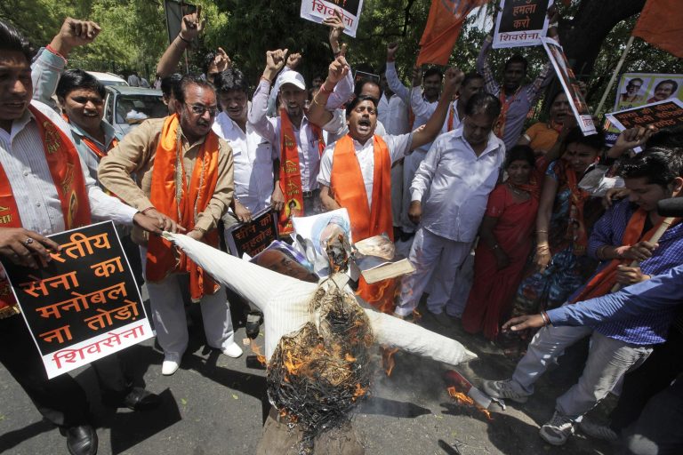 Indian protesters of right wing Shiv Sena party burn an effigy with photographs of India Defense Minister A.K.Antony, left, Prime Minister Manmohan Singh, center and Home Minister Sushil Kumar Shinde during a protest against the alleged incursion by Chinese troops into Indian territory in New Delhi, India, Wednesday, May 1, 2013. India said Chinese troops crossed the de facto border between the countries and went 10 kilometers (six miles) into Indian territory on April 15. About 50 Chinese soldiers were camping in tents Kashmir's Ladakh region. (AP Photo /Manish Swarup)
