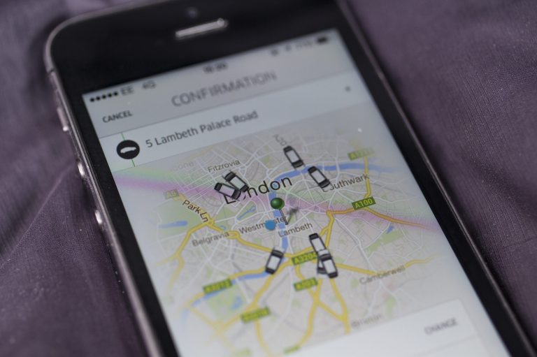 A smartphone displays the Uber mobile application which allows users to hail private-hire cars from any location. (Photo by Oli Scarff/Getty Images)