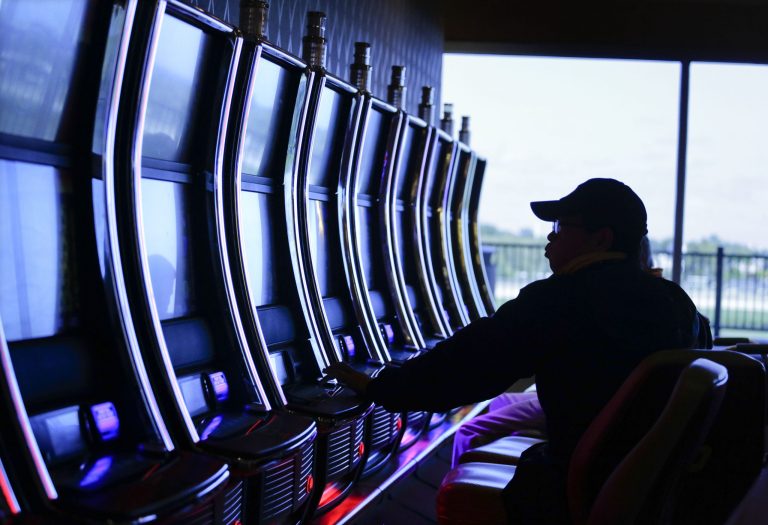 In this Friday, Oct. 3, 2014 photo, a visitor to the Resorts World Casino at the Aqueduct racetrack plays an electronic slot machine, in the Queens borough of New York. Just three years after opening, the casino has become the most successful racetrack casino in the world, and now the operators of Resorts World are hoping state regulators recognize that success as they decide among 16 applications seeking to operate as many as four upstate casinos. (AP Photo/Julie Jacobson)