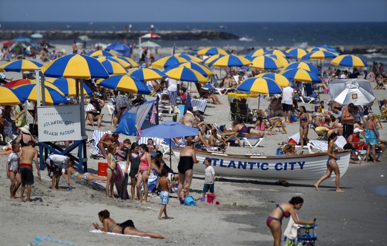 In this Wednesday, July 23, 2014 photograph people relax and play in the ocean in Atlantic City, N.J. Good weather and greater awareness that the Jersey shore has made huge strides in recovering from Superstorm Sandy helped make the second summer after the storm better than the first one, many shore merchants and elected officials say. Some business owners report profits up 20 to 30 percent in the summer of 2014 compared with 2013, when the shore was still in the early stages of recovering from the devastating Oct. 29, 2012, storm. (AP Photo/Mel Evans)
