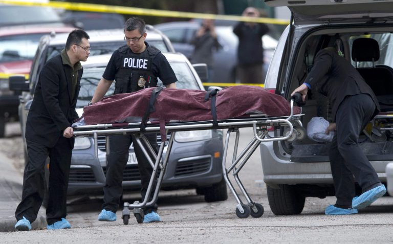 Police remove a body from the scene of a multiple fatal stabbing in northwest Calgary, Alberta, Tuesday, April 15, 2014. Police say five people are dead after the stabbing at a house party. (AP Photo/The Canadian Press, Larry MacDougal)