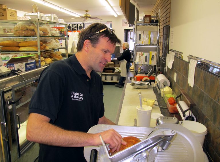 P.J. Whelan, the owner of Lindell Delicatessen in Long Beach, N.Y., prepares a sandwich in his establishment on Monday, April 21, 2014. (AP Photo/Frank Eltman)
