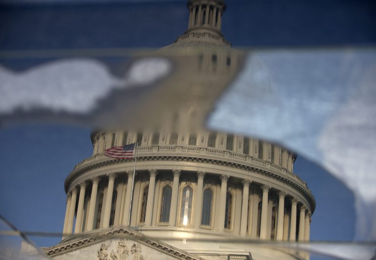 The Capitol Dome is seen reflected in water pooled on panels of glass on the visitors center on Capitol Hill in Washington, Thursday, Sept 12, 2013, as the Republican controlled House and the Democrat controlled Senate will have to work together to to avoid a government shutdown after the 2013 budget year ends Sept. 30. (AP Photo/Carolyn Kaster)