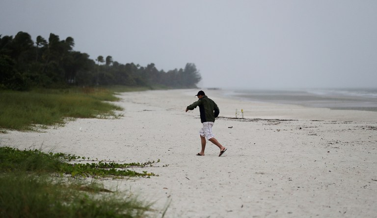 A beachgoer runs off the beach as the early effects of Hurricane Irma pick up in Naples, Fla., Sunday, Sept. 10, 2017. (AP Photo/David Goldman)